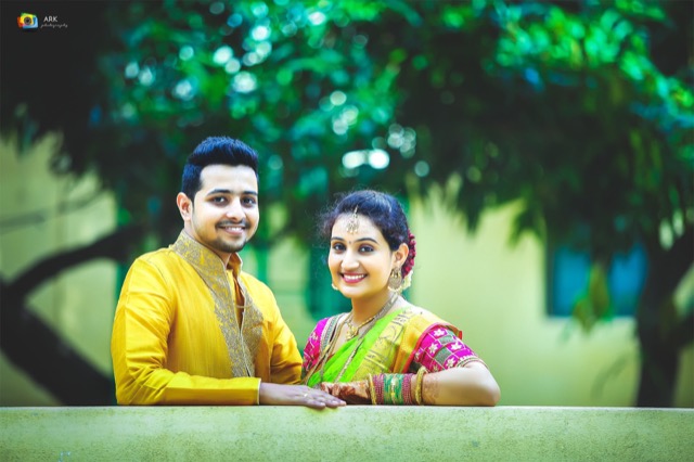 Smiling couple in coordinated yellow outfits in a garden