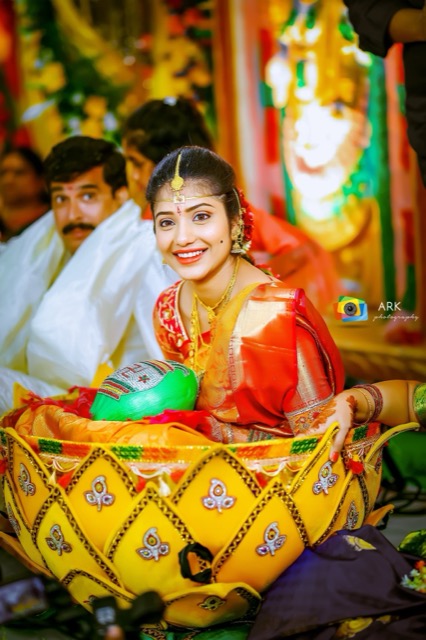 Bride seated in the decorated bamboo basket during a Telugu wedding ritual