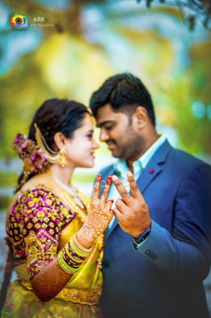 Engaged couple holding up their hands to show their rings
