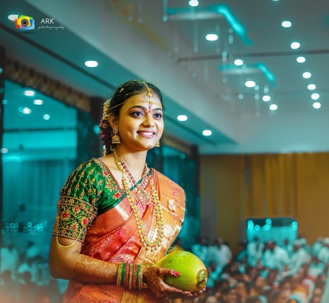 Bride holding a coconut during the wedding ceremony in a decorated hall