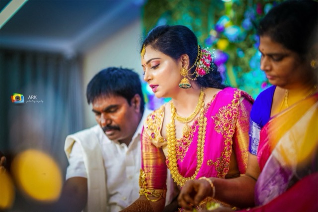 Bride and groom performing a ritual with family around them