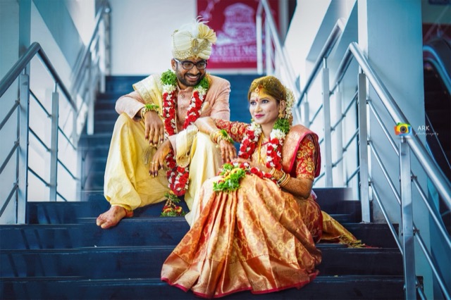 Newly married couple seated on a staircase in traditional attire