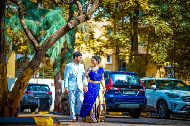 Couple walking hand in hand along a tree-lined road