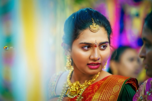Close portrait of a bride with colourful lights behind her